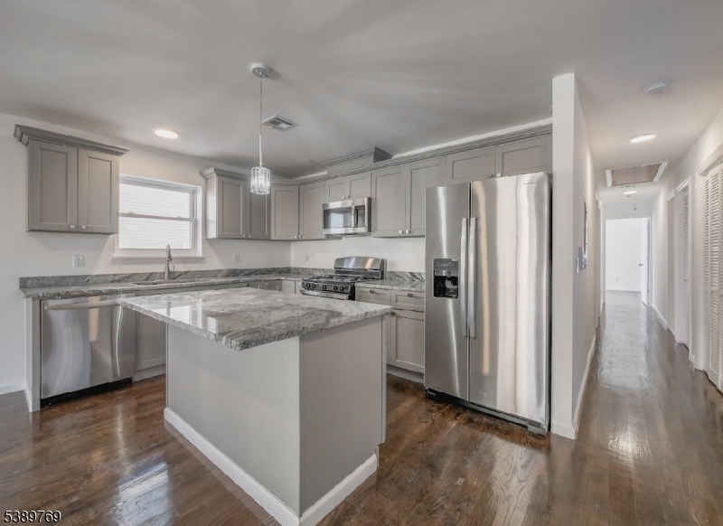 496 South 18th Street Newark, NJ 07103 - Photo 2 of 14 a kitchen with stainless steel appliances granite countertop a refrigerator a sink dishwasher a stove and white countertops with wooden floor