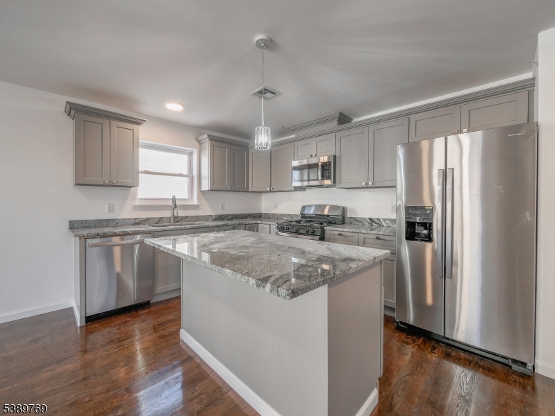 496 South 18th Street Newark, NJ 07103 - Photo 5 of 14 a kitchen with stainless steel appliances granite countertop a refrigerator a sink dishwasher a stove top oven a refrigerator and white cabinets with wooden floor