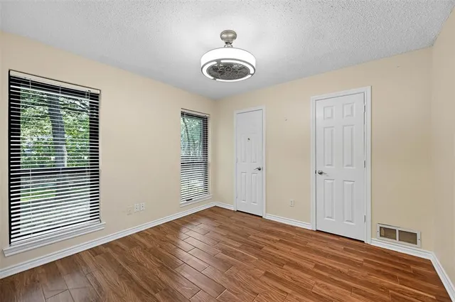 a view of empty room with wooden floor