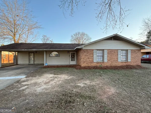 a front view of a house with a garden and yard