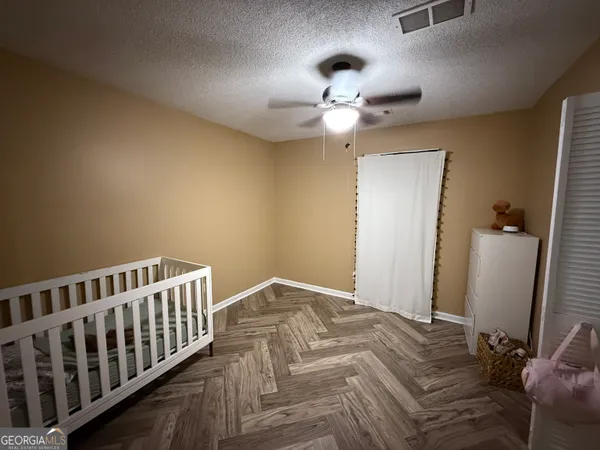 a bedroom with bed and wooden floor