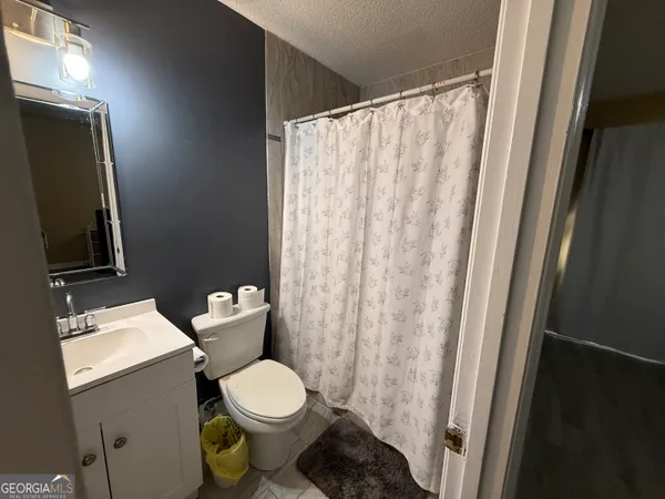 a white toilet sitting next to a shower curtain