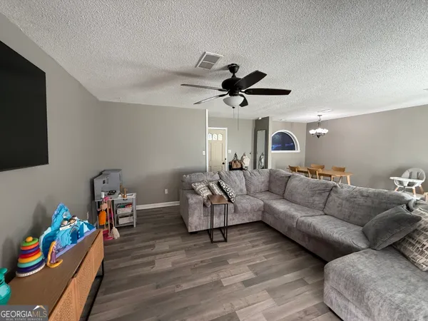 a living room with furniture and wooden floor