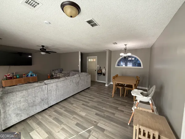 a living room with furniture and a wooden floor