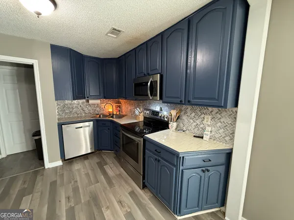 a kitchen with granite countertop wooden cabinets and stainless steel appliances