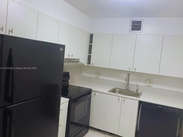 a kitchen with a sink and a refrigerator