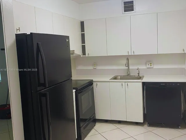 a kitchen with a refrigerator and cabinets