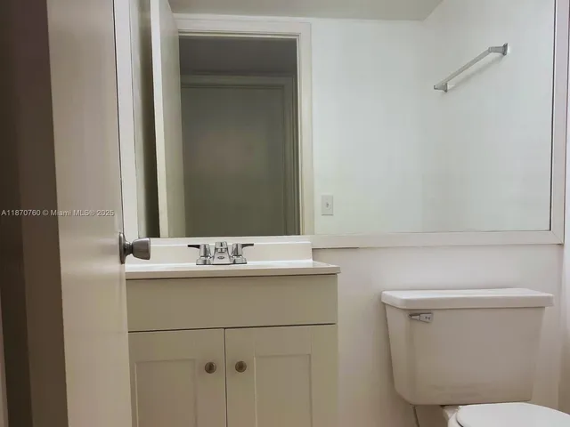 a bathroom with a sink a toilet and mirror