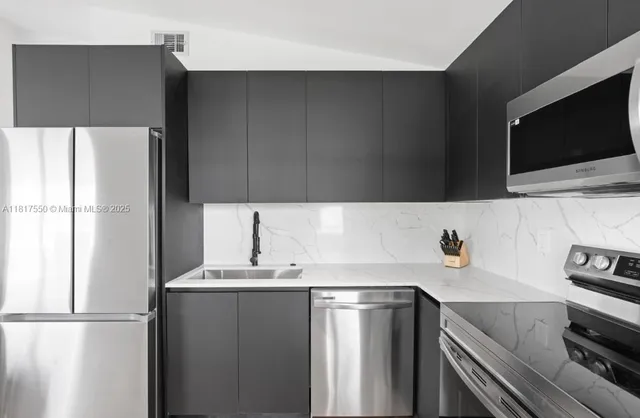 a kitchen with a sink and a stove top oven