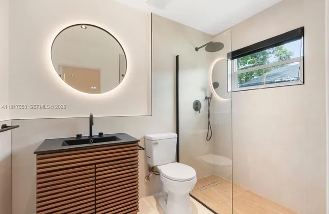 a bathroom with a toilet a sink and mirror