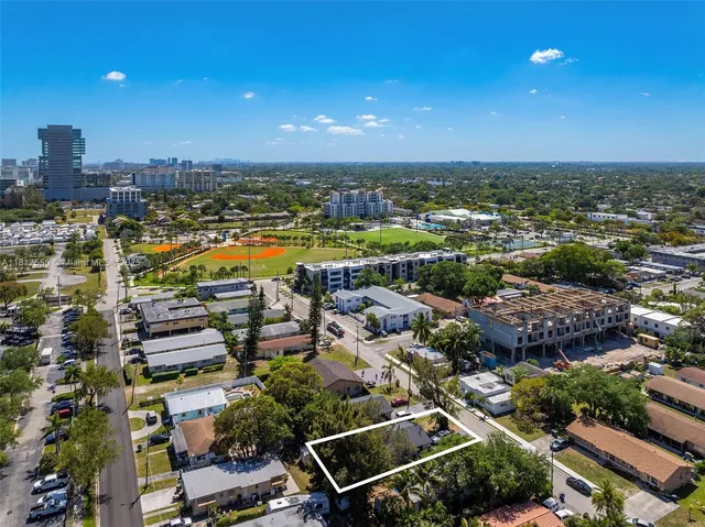 an aerial view of a city with lots of residential buildings ocean and mountain view in back