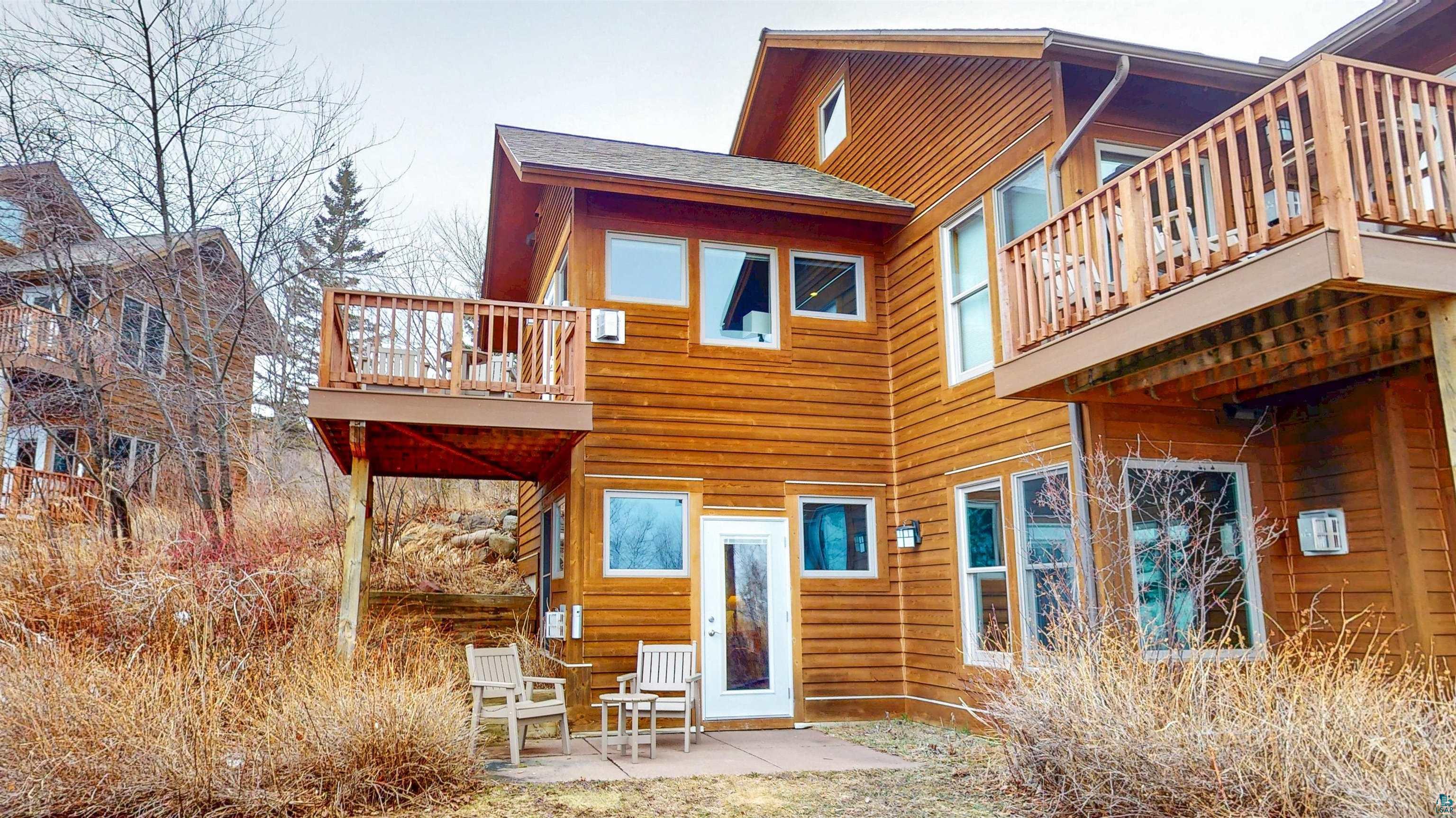 504-506 Poplar River Road, Unit 505 Lutsen, MN 55612 - Photo 20 of 39 Cedar-sided exterior with multiple balconies and a ground-level patio