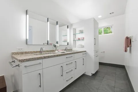 a bathroom with a granite countertop sink and a mirror