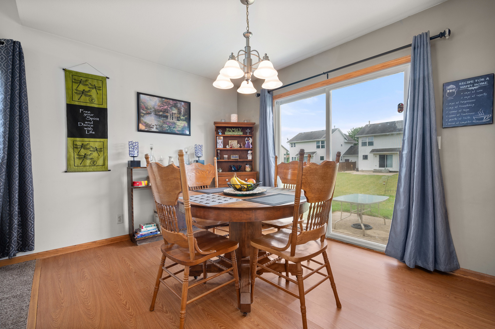 720 Hawthorne Lane Genoa, IL 60135 - Photo 7 of 25 a dining room with furniture a chandelier and wooden floor