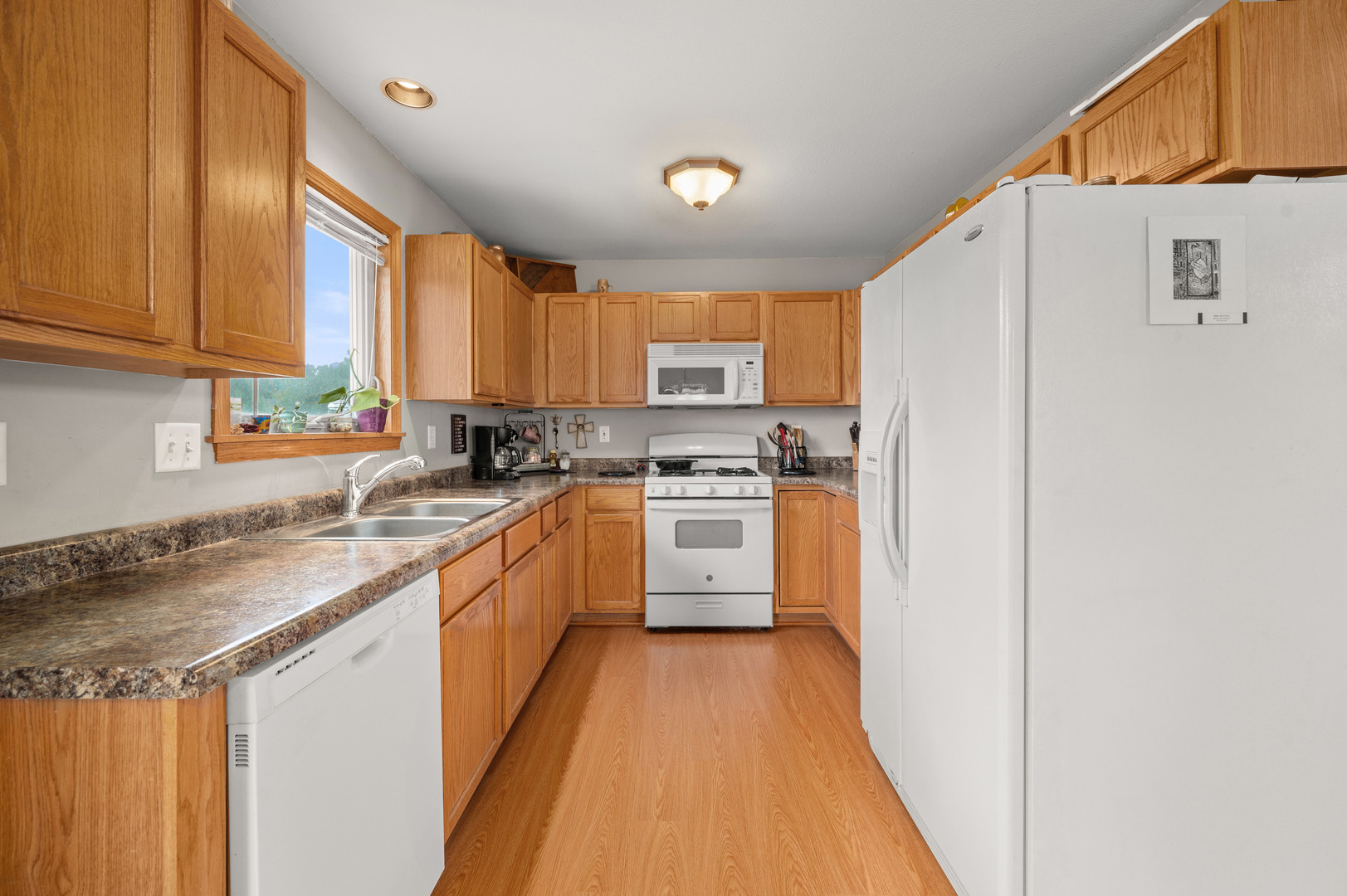 720 Hawthorne Lane Genoa, IL 60135 - Photo 8 of 25 a kitchen with white cabinets and white appliances