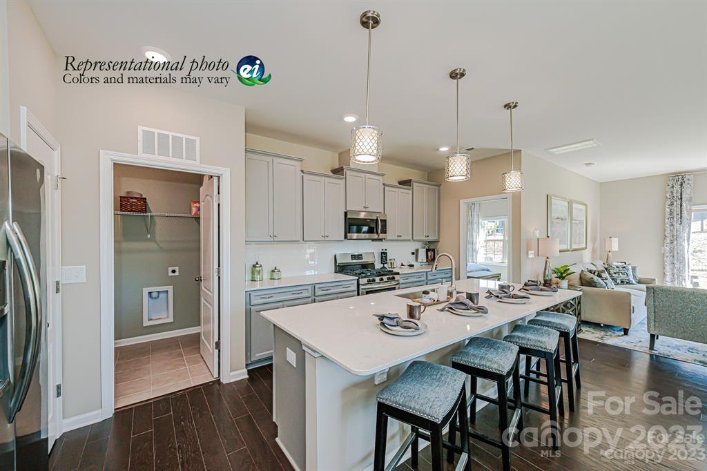 6587 Gopher Road, Unit 343 Lancaster, SC 29720 - Photo 3 of 19 a kitchen with a dining table chairs refrigerator and cabinets