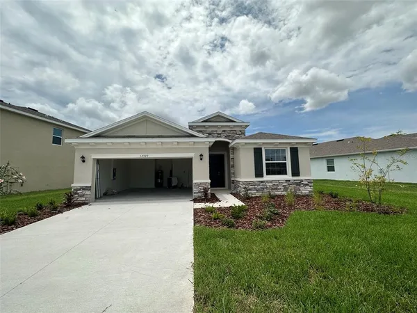 a front view of a house with a garden and yard
