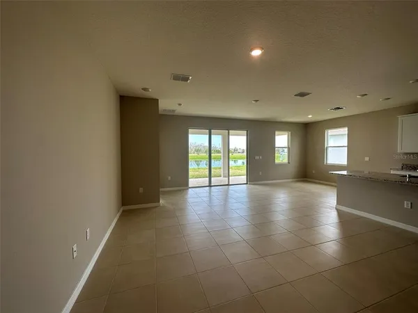 a view of an empty room with glass door and windows