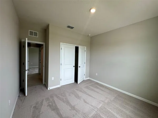 an empty room with closet and a bathroom