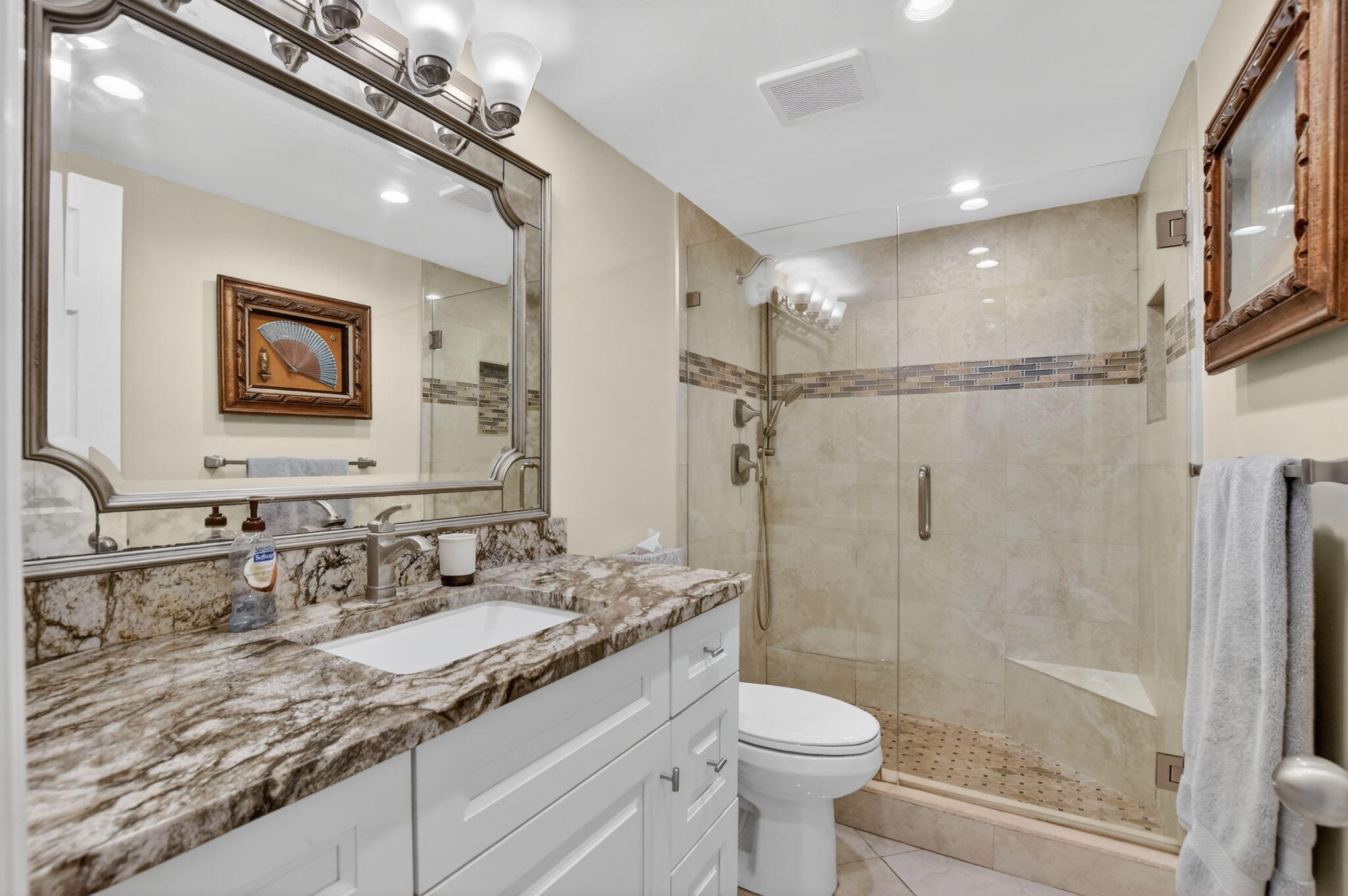250 Northeast 20th Street, Unit 1170 Boca Raton, FL 33431 - Photo 19 of 40 a bathroom with a granite countertop sink a toilet a mirror and shower