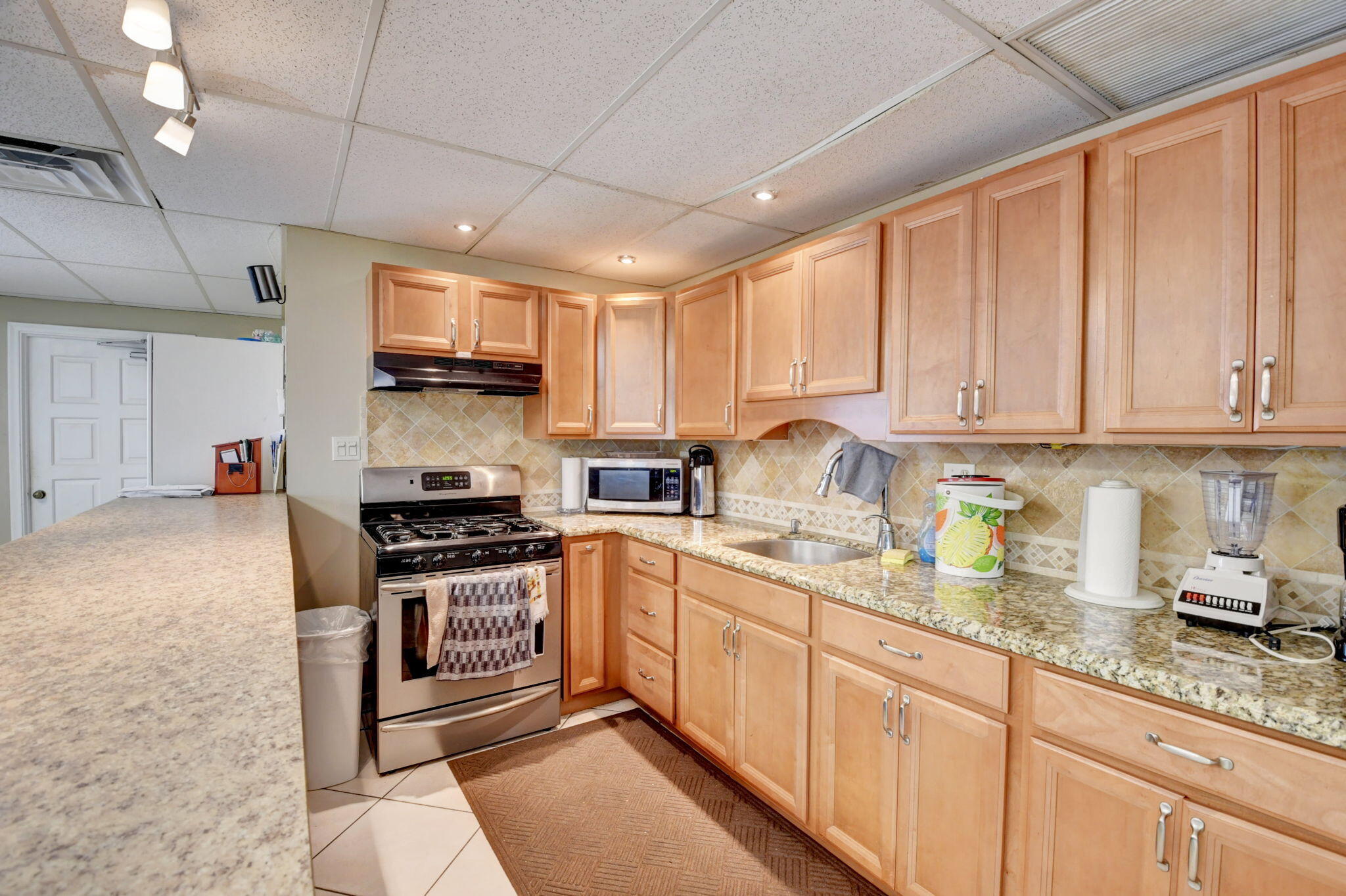 250 Northeast 20th Street, Unit 1170 Boca Raton, FL 33431 - Photo 40 of 40 a kitchen with stainless steel appliances granite countertop a stove sink and cabinets