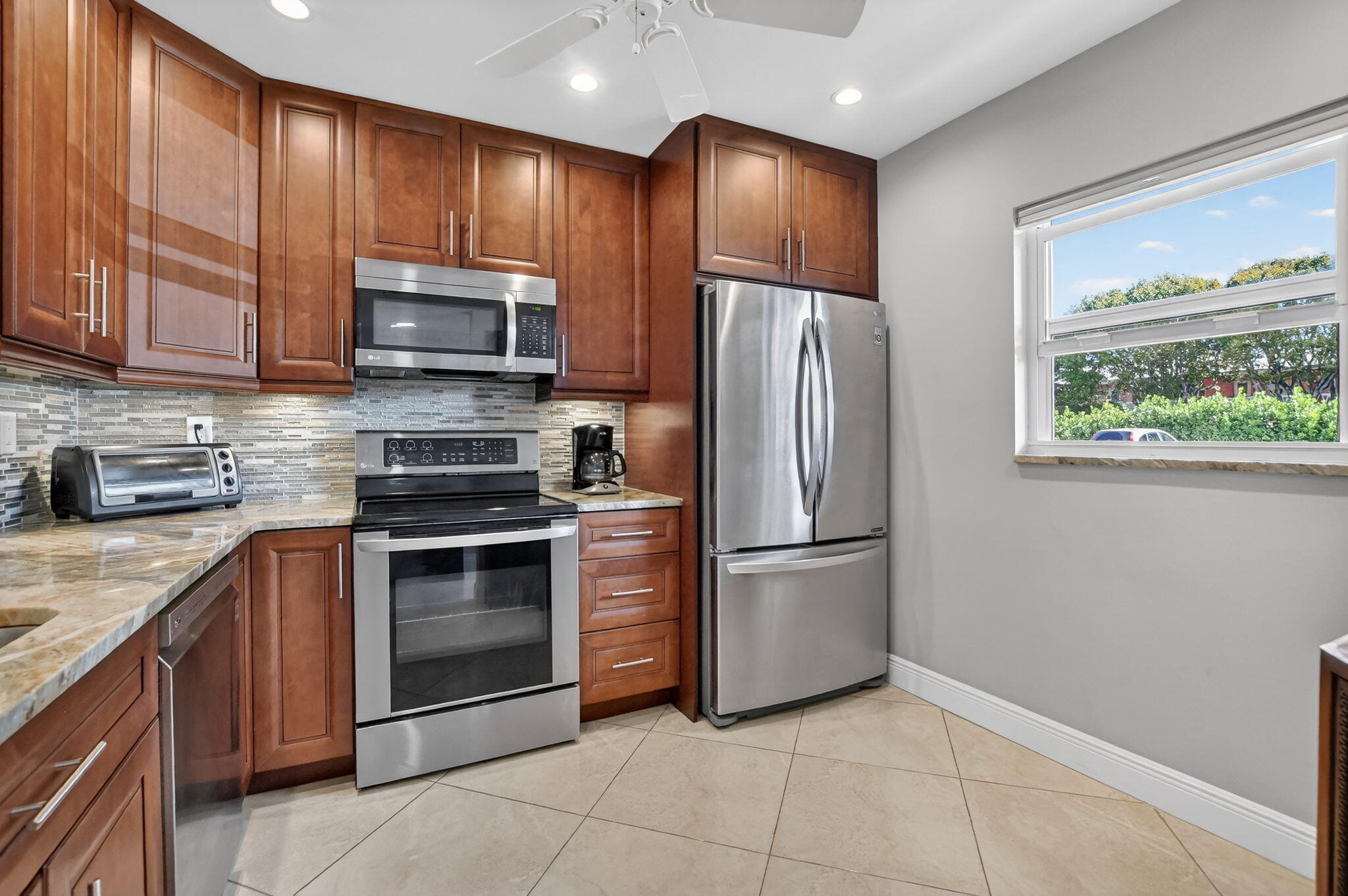 250 Northeast 20th Street, Unit 1170 Boca Raton, FL 33431 - Photo 7 of 40 a kitchen with stainless steel appliances granite countertop a refrigerator stove and microwave