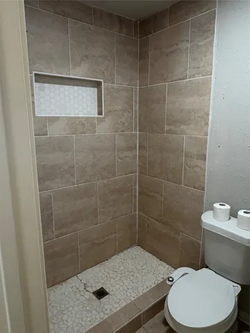 a bathroom with a toilet and a shower