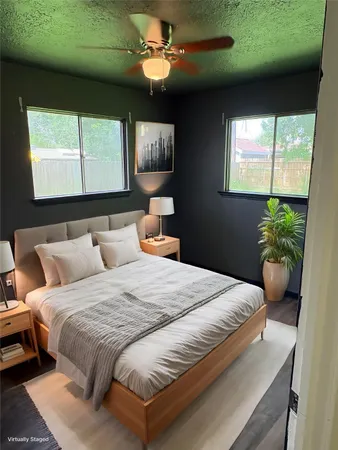 a bedroom with a large bed and a potted plant