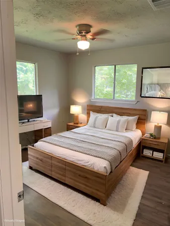 a bedroom with bed and a flat screen tv