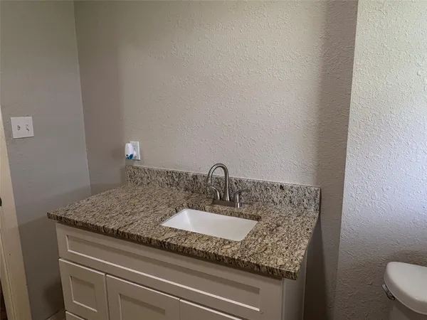 a bathroom with a granite countertop sink and a mirror