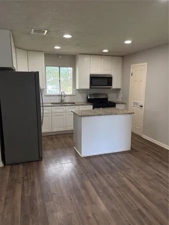 a kitchen with stainless steel appliances wooden floors and wooden cabinets