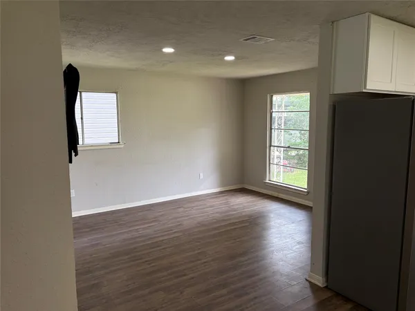an empty room with wooden floor and a window