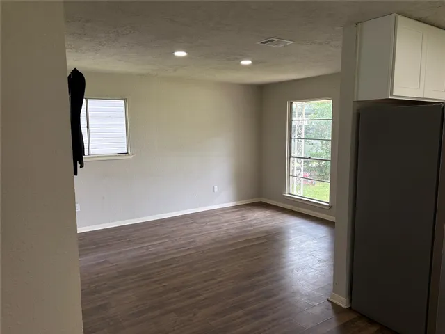 an empty room with wooden floor and a window