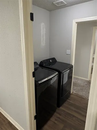 a utility room with wooden floor washer and dryer