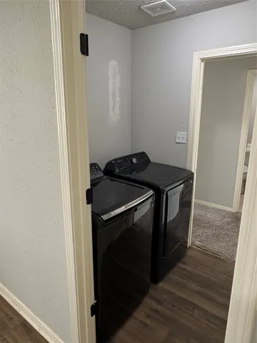 a utility room with wooden floor washer and dryer