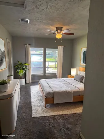 a bedroom with a bed dresser and window