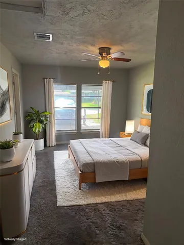 a bedroom with a bed dresser and window