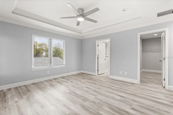 a view of an empty room with a window and wooden floor