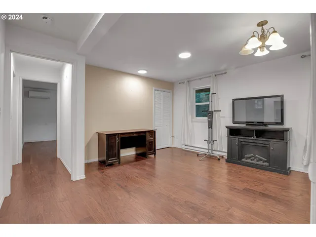 a view of an empty room with window wooden floor and chandelier