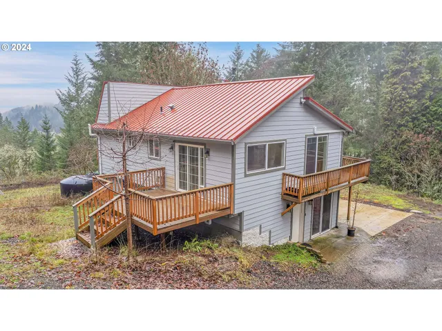 a backyard of a house with wooden fence and large trees