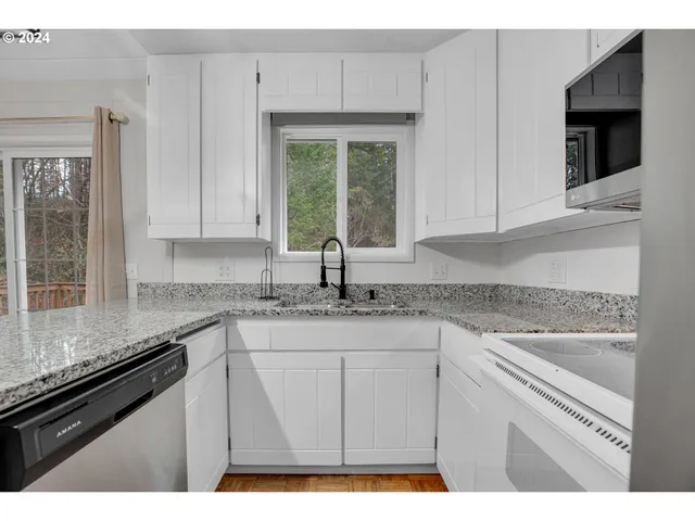 a kitchen with granite countertop a sink cabinets and window