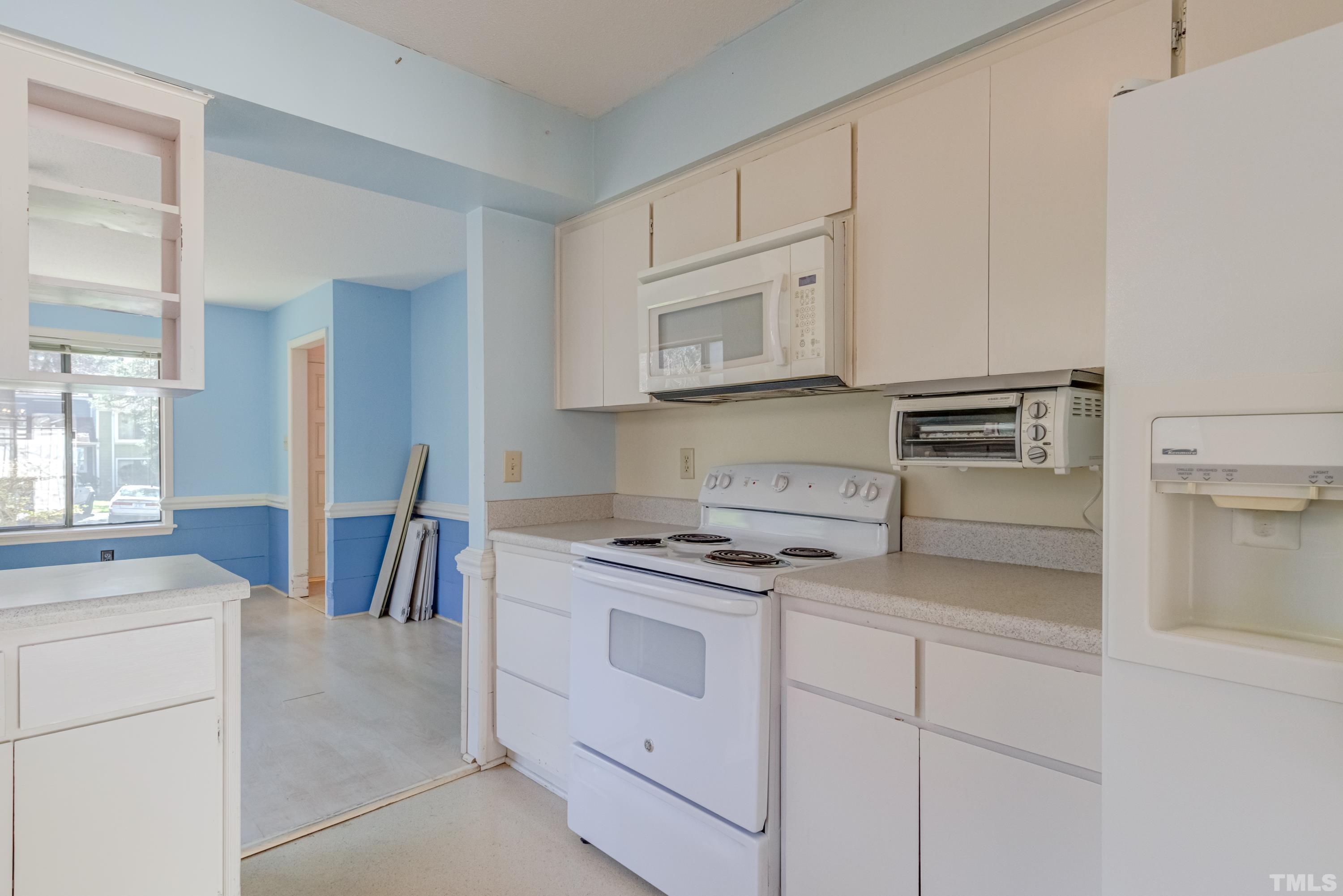 5869 Branchwood Road Raleigh, NC 27609 - Photo 24 of 35 a kitchen with white cabinets and appliances