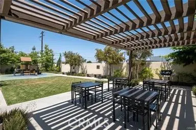 a view of a patio with table and chairs and potted plants with wooden floor and fence