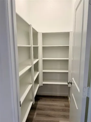 a kitchen with stainless steel appliances kitchen island granite countertop a refrigerator oven a sink and dishwasher with wooden floor