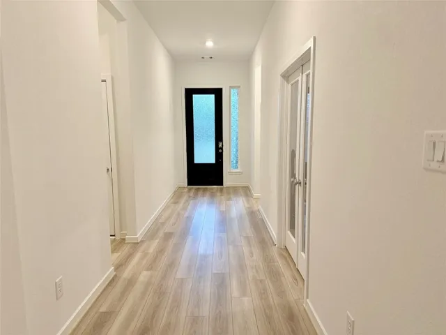a view of a hallway with wooden floor