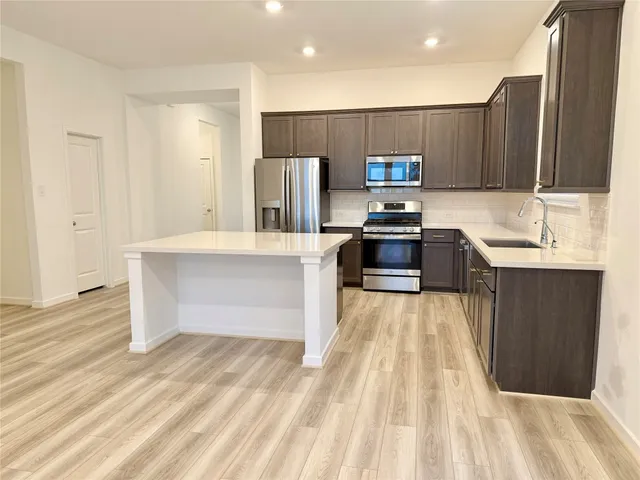 a kitchen with a sink cabinets and wooden floor