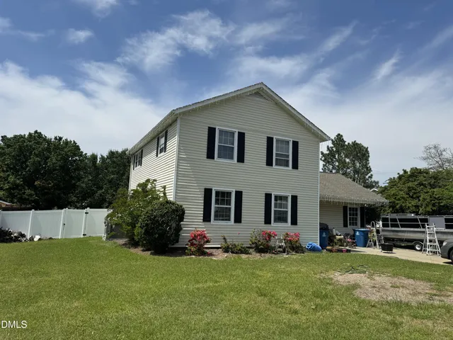 a front view of a house with a garden and yard