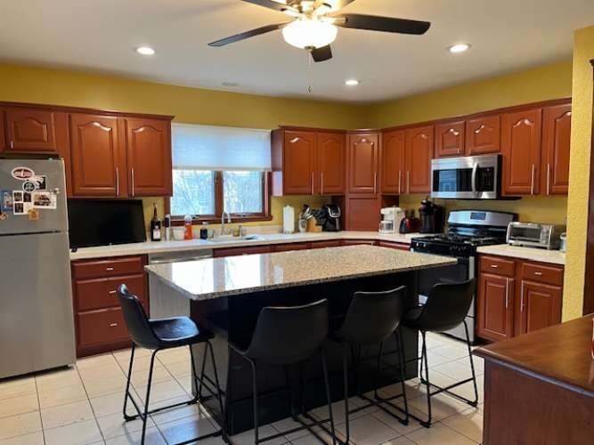 43 Loring Road Winthrop, MA 02152 - Photo 11 of 21 a kitchen with stainless steel appliances granite countertop a sink a stove a refrigerator cabinets and chairs