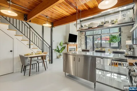 a dining room with furniture floor to ceiling windows and a chandelier