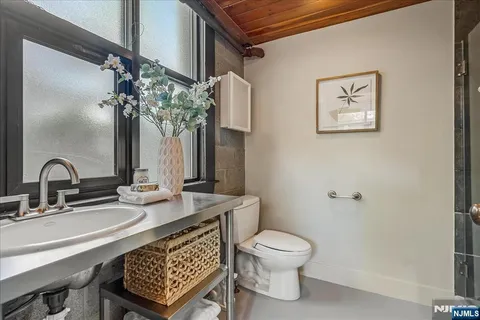 a bathroom with a toilet a sink and mirror
